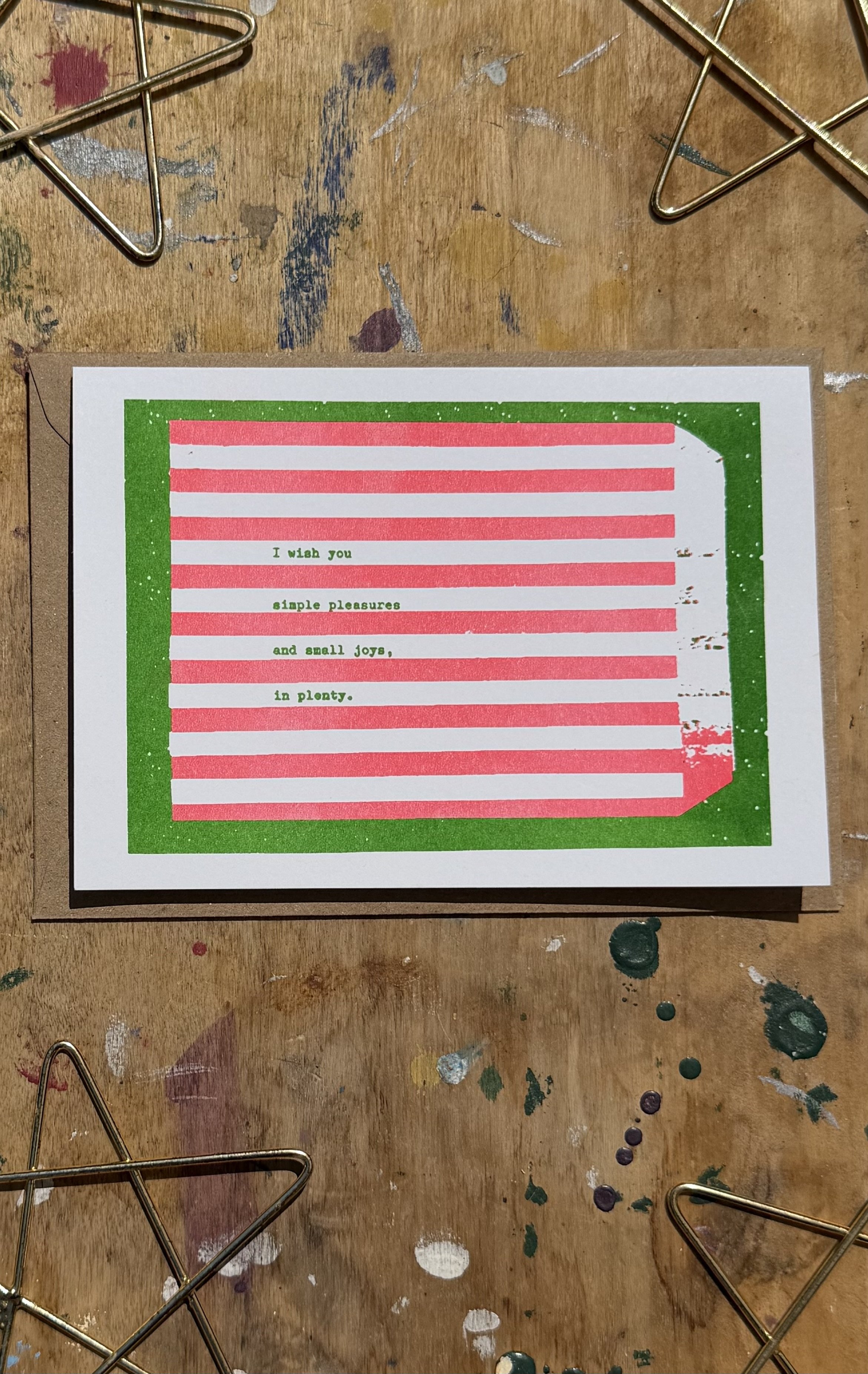 A6 risograph christmas card with red and green stripes and text reading "I wish you simple pleasures and small joys, in plenty." Independently made christmas cards from a small business.