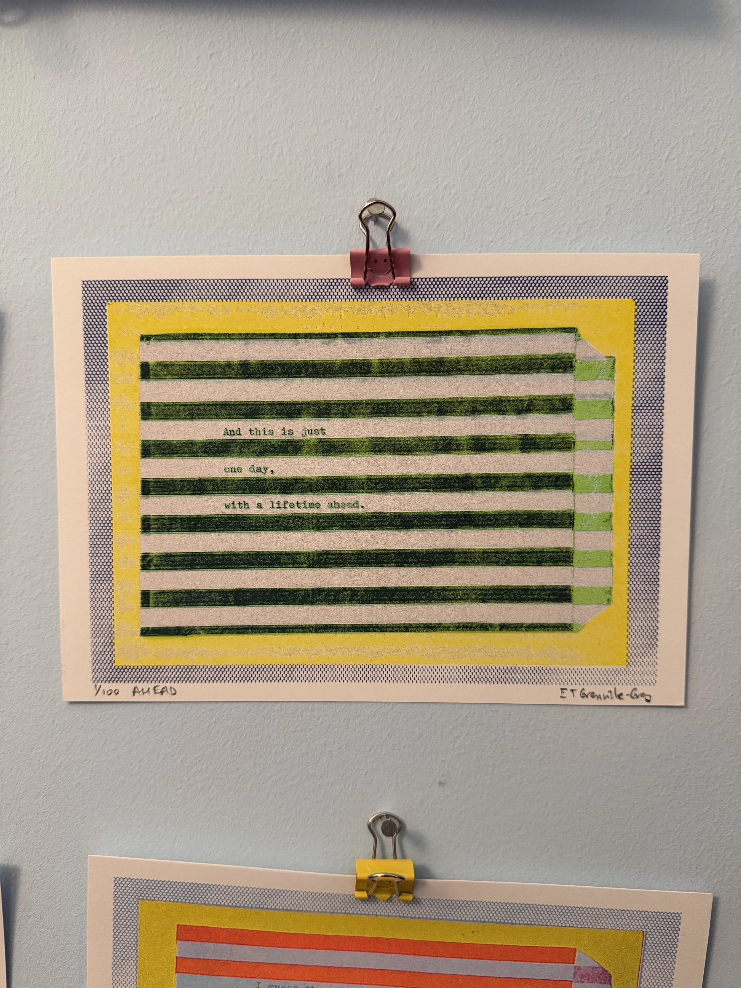 A5 risograph art print in green and yellow tones with poetic text about time and the future, clipped against a pale wall