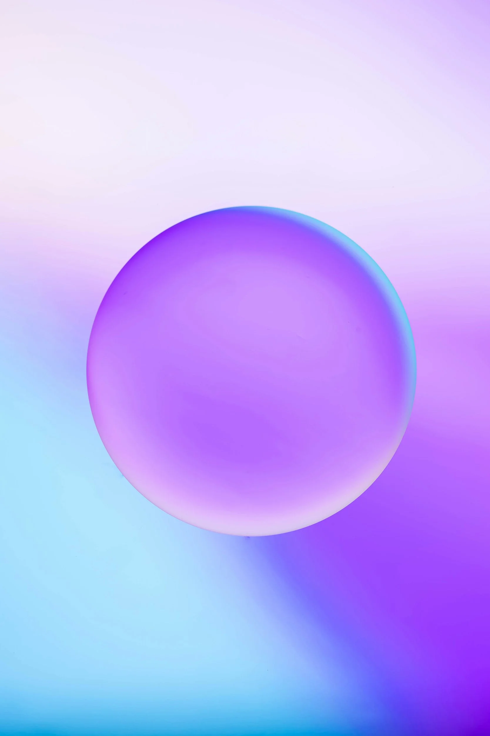 A large, glowing purple and blue spherical object against a pastel-colored background.