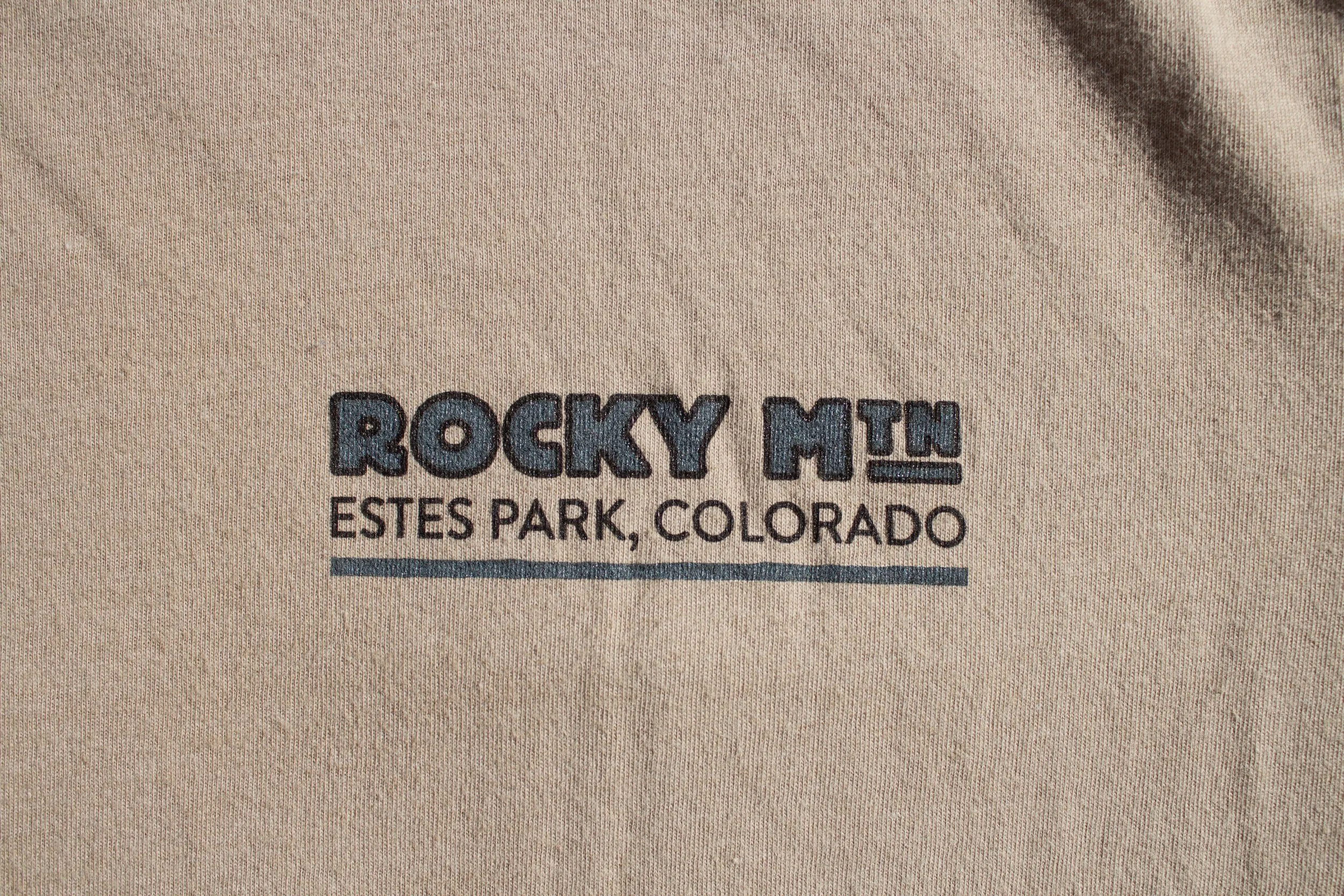 A closeup of the left breast pocket graphic that says Rocky Mtn Estes Park Colorado