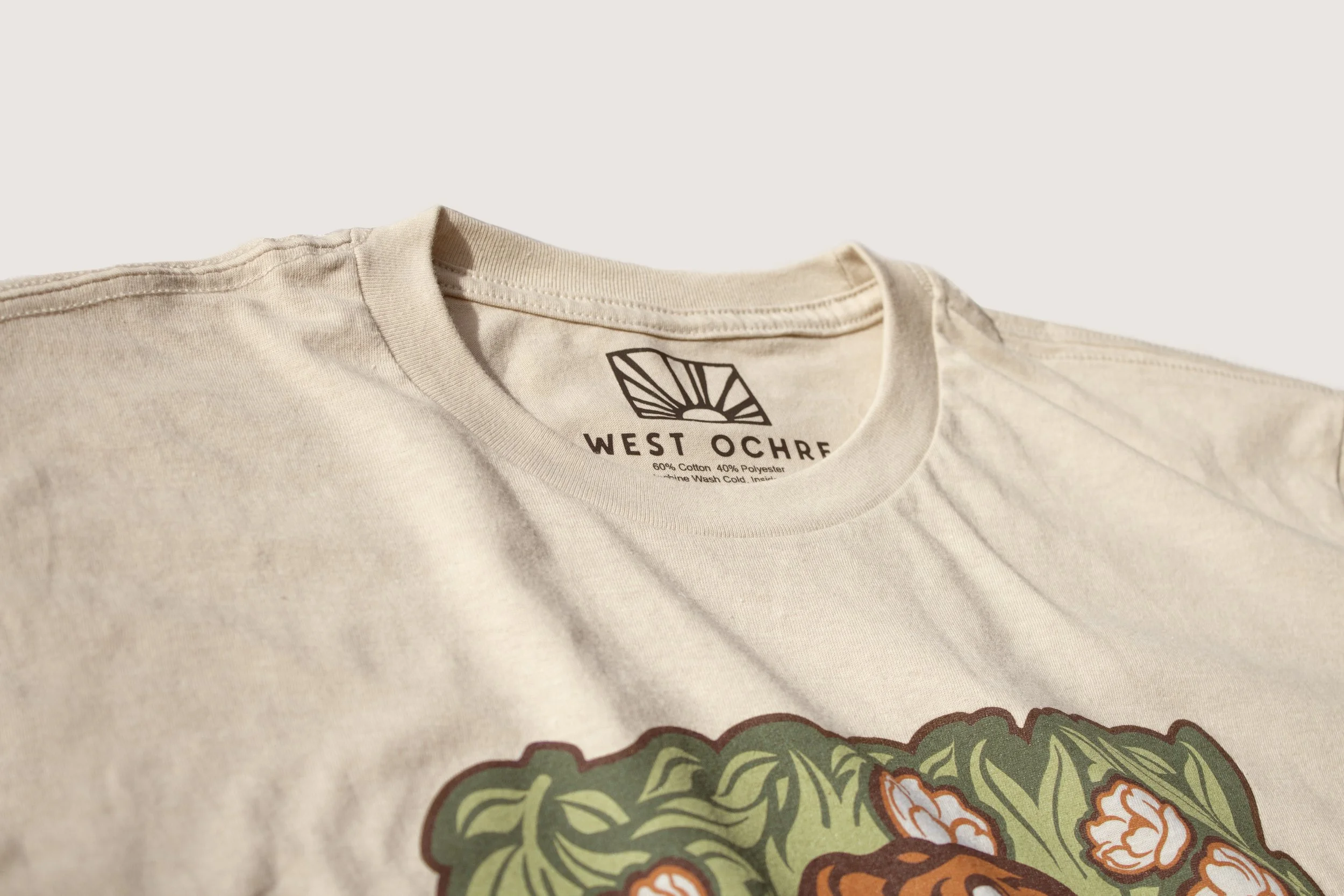 A cropped picture showing the neck label on a cream t-shirt