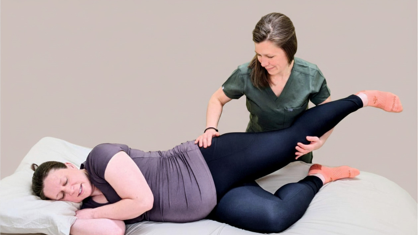 Pregnant woman receiving physical therapy on a bed, lying on her side with a therapist holding her raised leg.