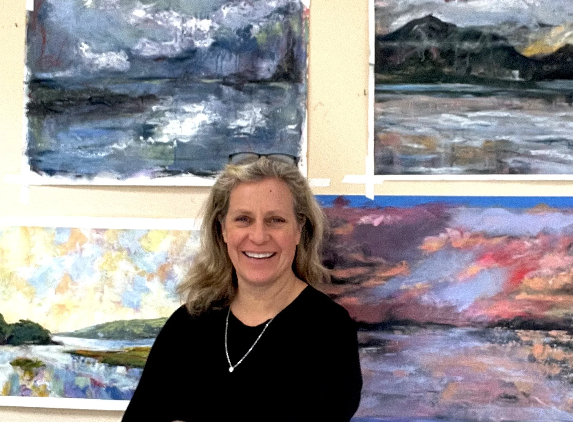 Artist Gabrielle England in her Olympia, Washington studio with acrylic mixed media landscape paintings during the South Sound Studio Tour.