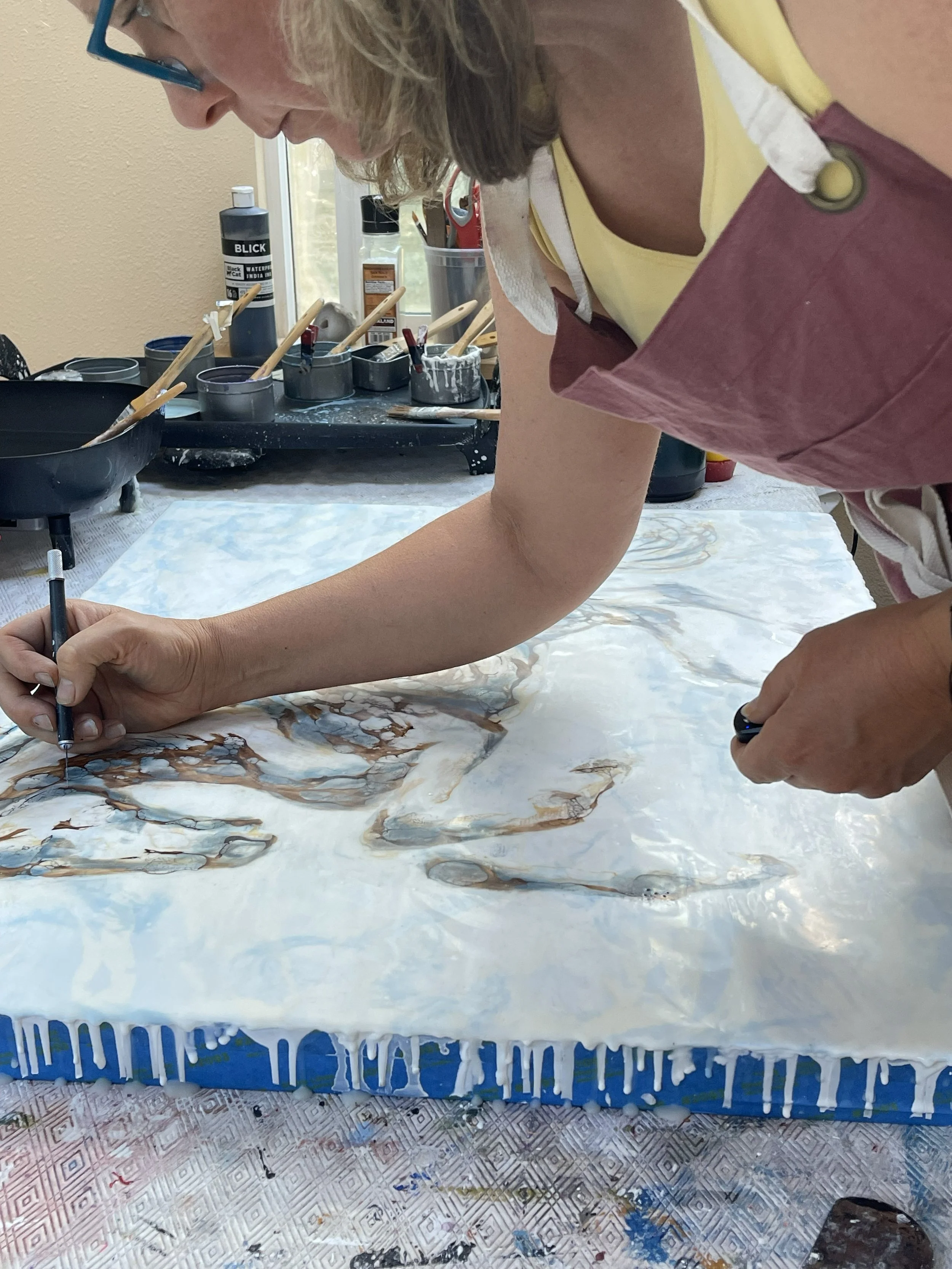 Gabrielle England workingnon a detailed part of her encaustic painting as part of process.