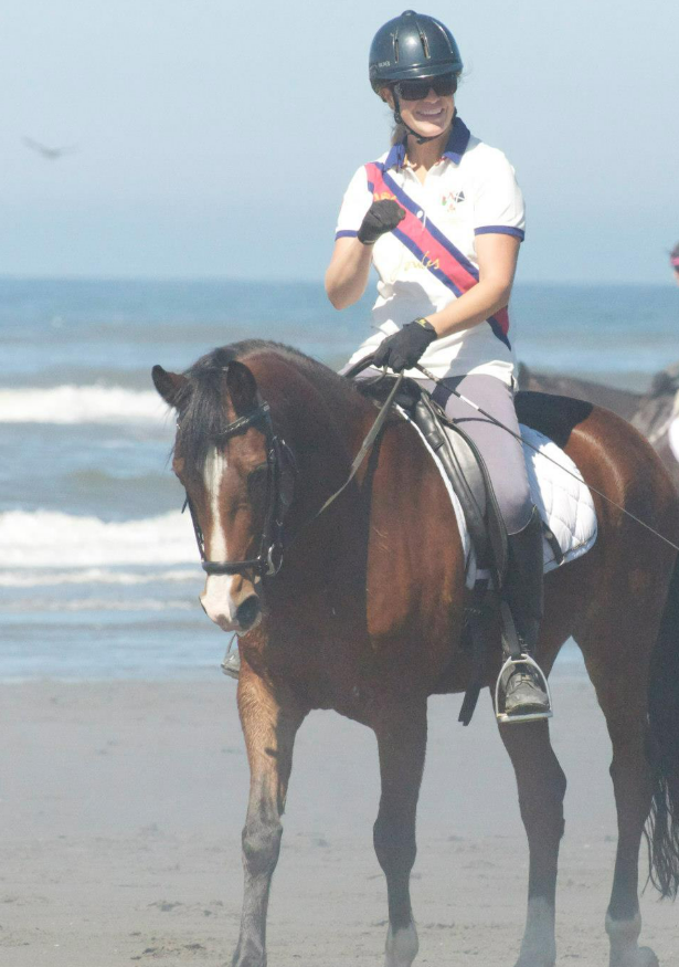 Gabrielle England horseback riding on the beach.