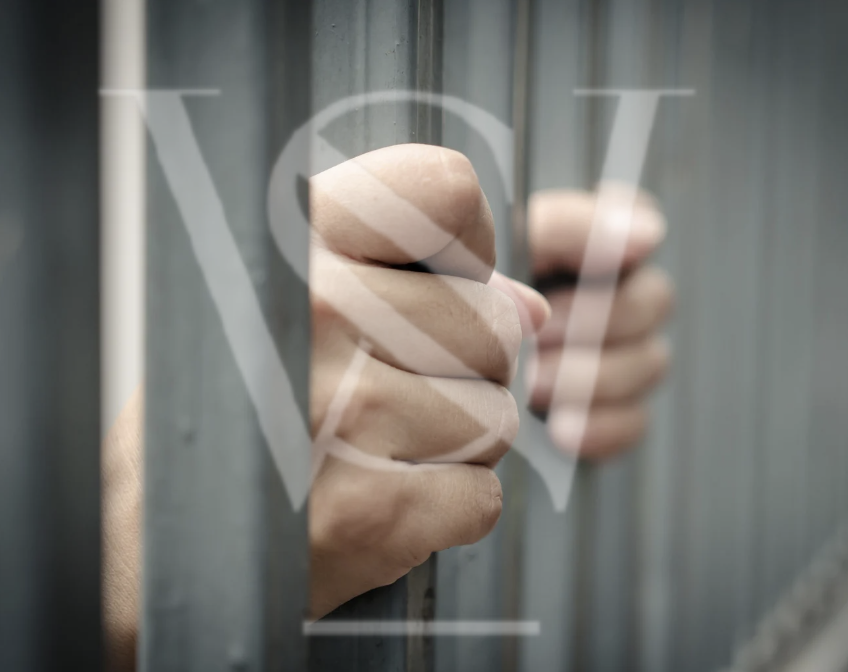Close-up of a person's hand making a fist behind a glass panel with a heart-shaped logo and the text 'LOVE' printed on it.