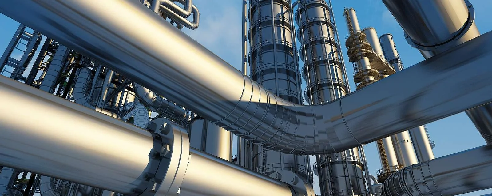 Close-up view of industrial pipes and tanks at an oil refinery or chemical plant.