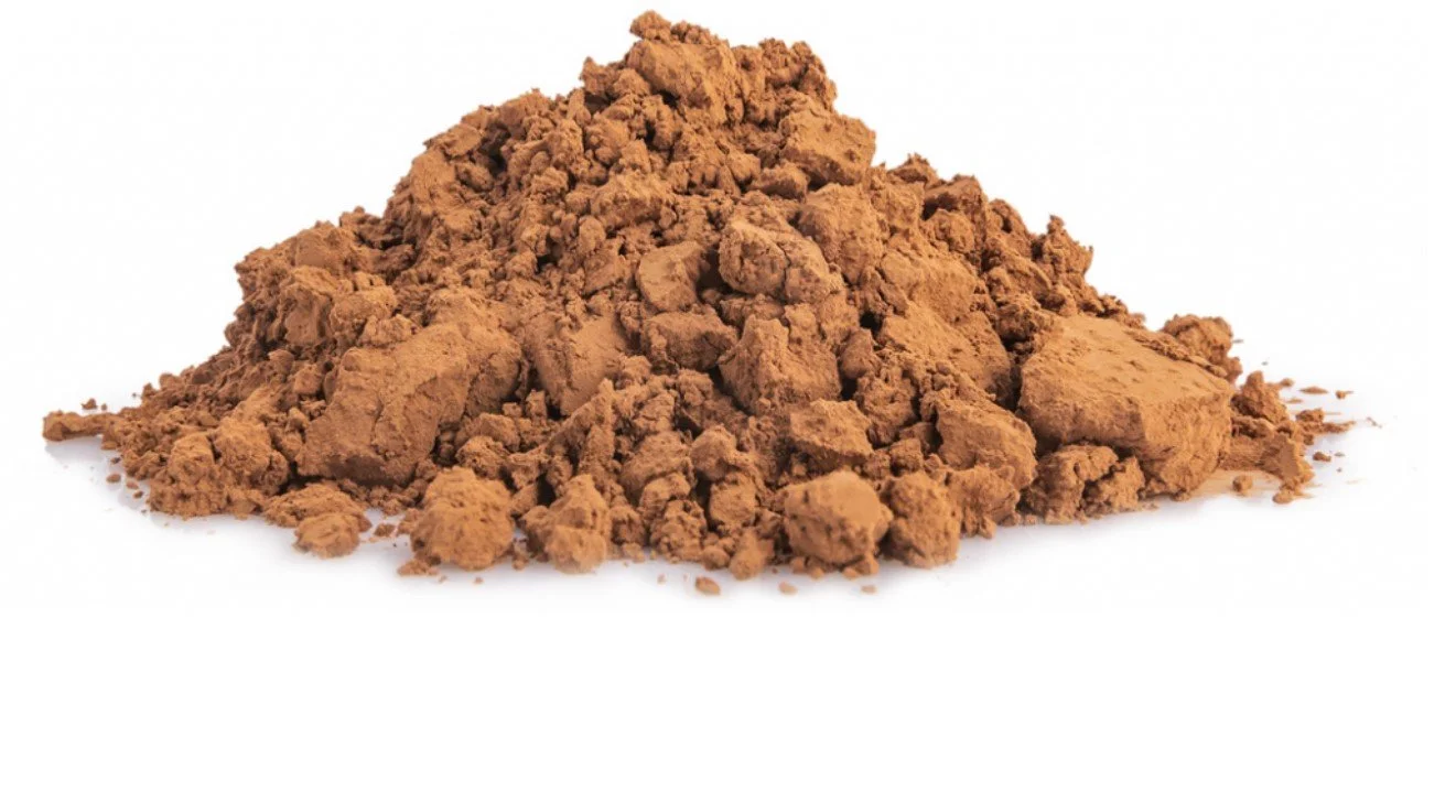 Pile of brown ground cinnamon on a white background.