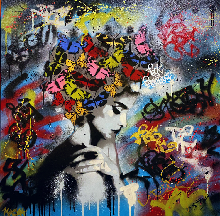 A black and white mural of a woman with her eyes closed, with colorful butterflies on her head, surrounded by vibrant graffiti and splashes of spray paint in various colors.
