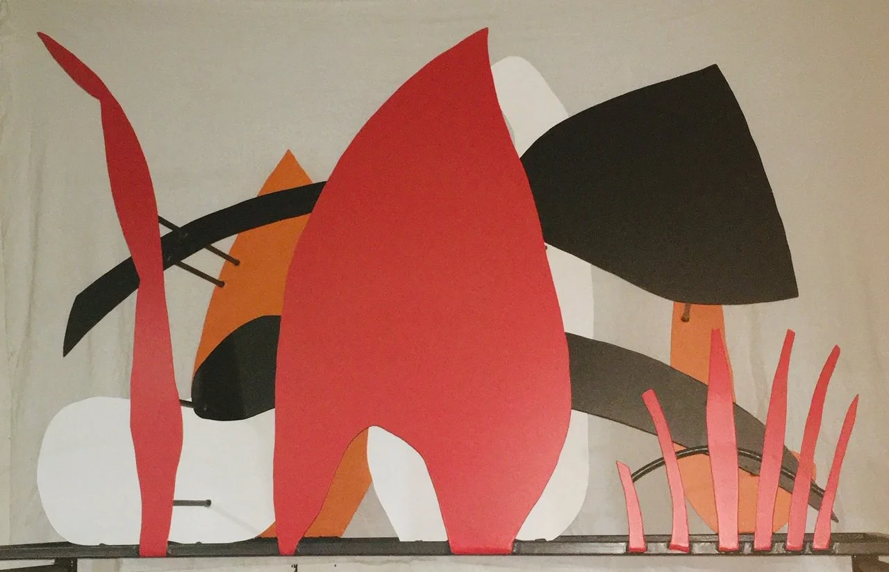 Abstract modern art mural with bold shapes and colors, including red, black, white, orange, and pink elements.