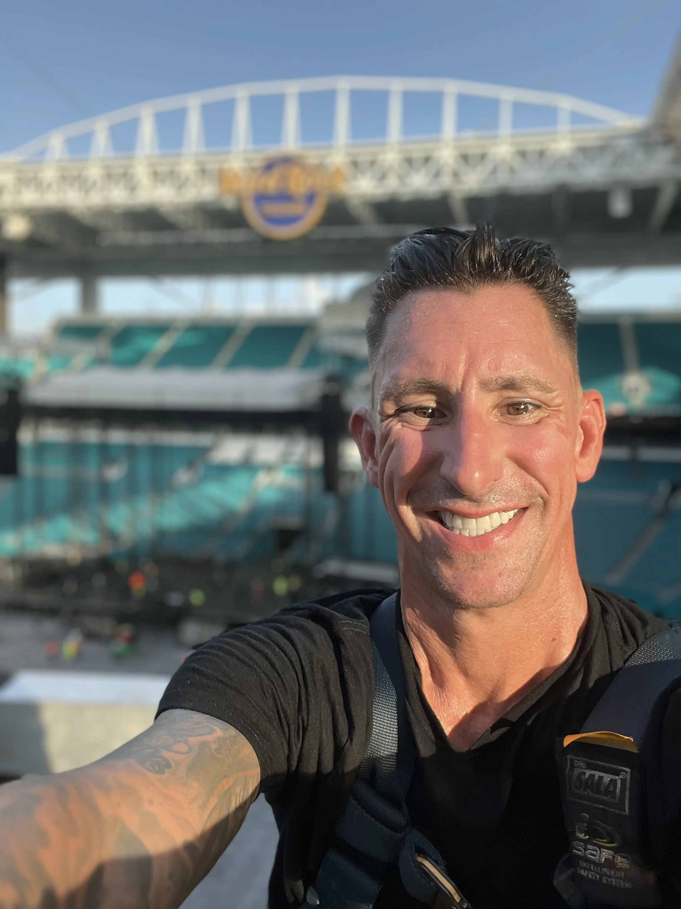 Jason Arthur, owner of Stage Design & Technology Services smiling for a selfie at a Hard Rock Stadium in Miami Gardens, Florida.