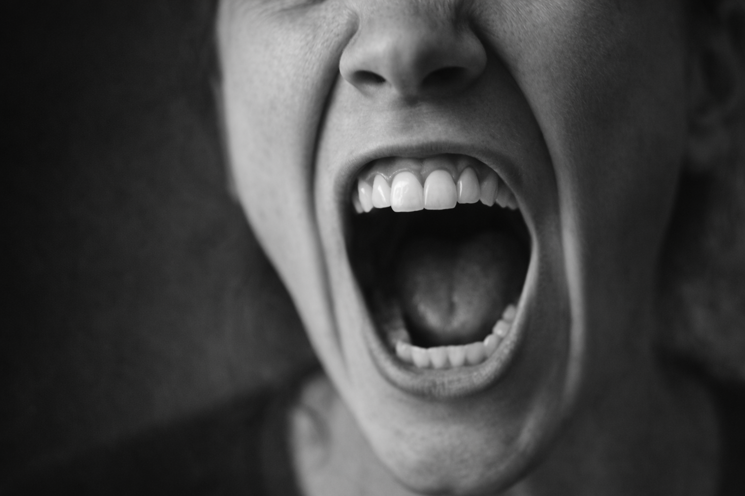 Imagen en blanco y negro de una boca gritando que representa rabietas intensas y desregulación emocional.
