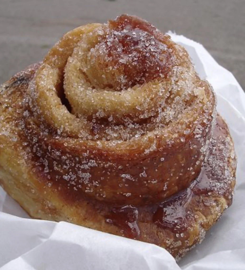 Close-up of a cinnamon roll with sugar and glaze.