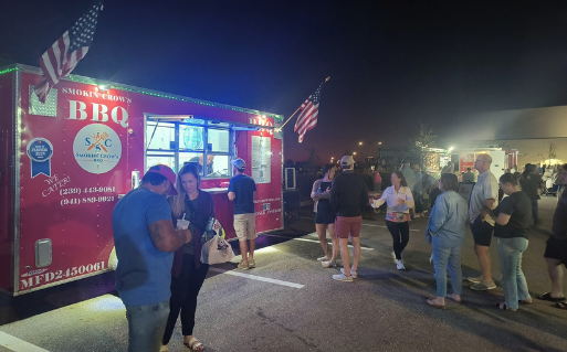 Guests waiting in line at Smokin’ Crow’s BBQ food truck during a community event in Southwest Florida.