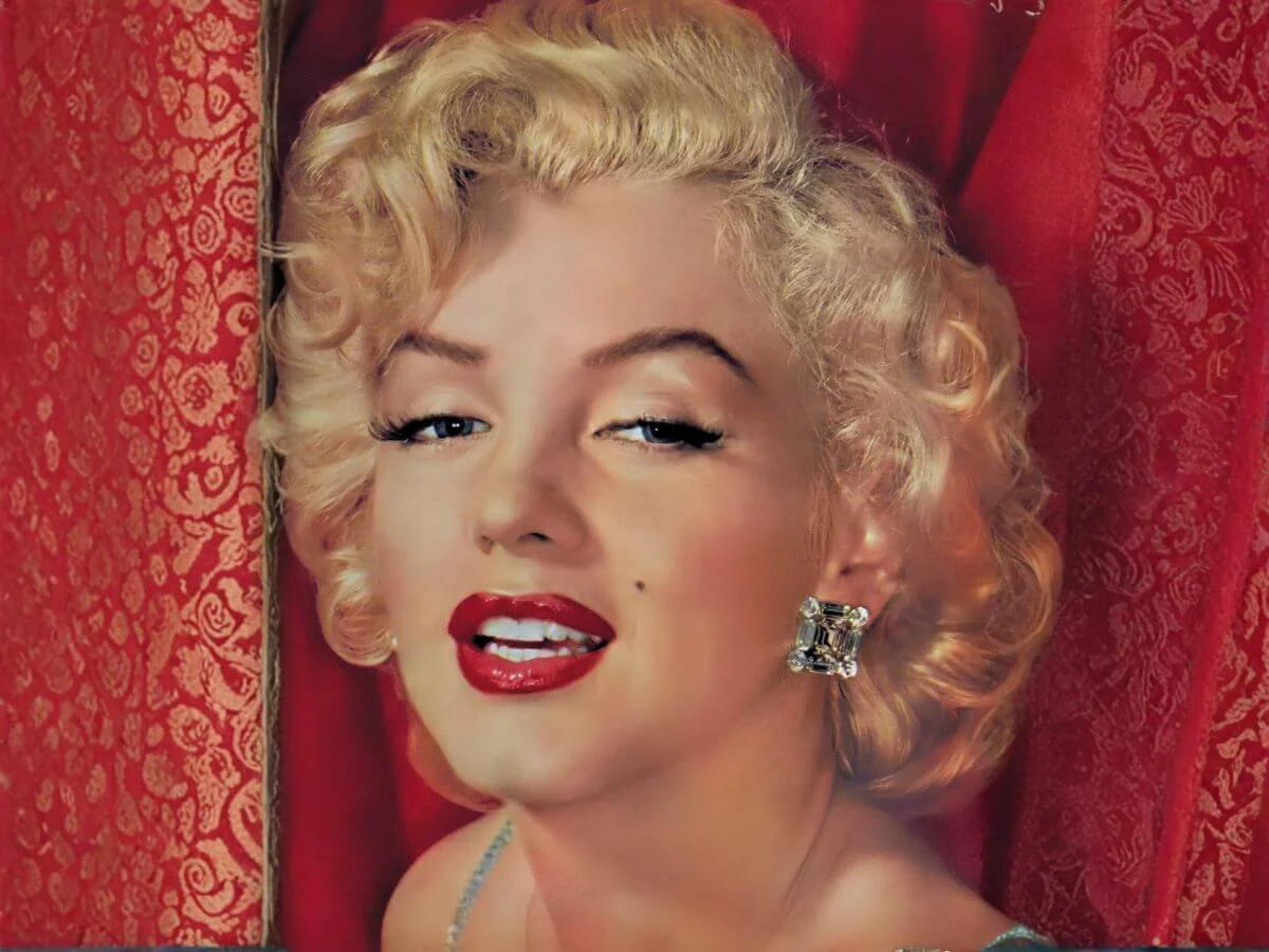 Marilyn Monroe posing against a red backdrop