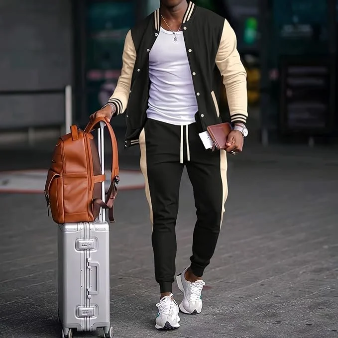 Person dressed in casual black and beige jacket with black pants and white sneakers, pulling a silver suitcase and carrying a brown backpack, holding a wallet or passport in hand at an airport or transit station.