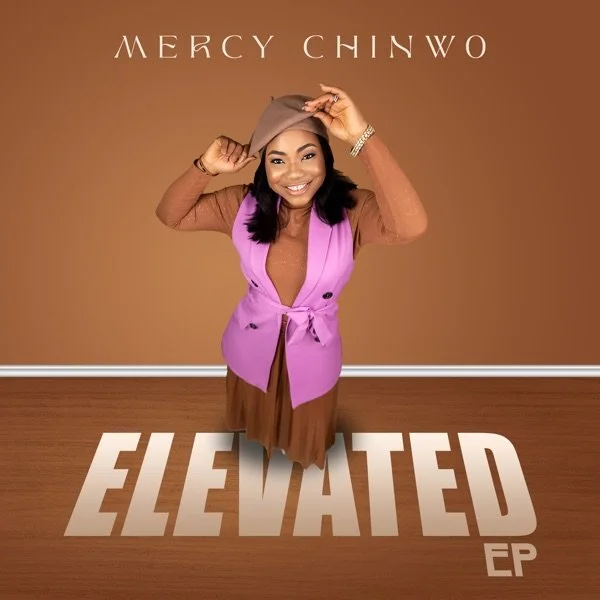 The album cover for Mercy Chinwo's EP titled 'Elevated' features a woman smiling and holding a beige hat, standing against a plain brown background with the artist's name at the top and the album title in large white bold letters on the floor.