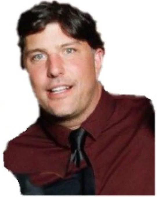 Smiling man with dark hair wearing a maroon dress shirt and black tie, photographed against a light background.