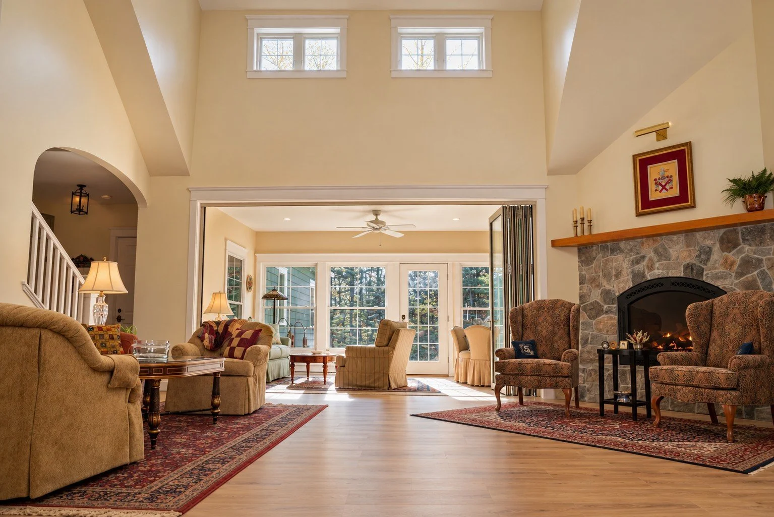 Vaulted family room with clerestory windows opening to the sunroom through a glass accordion door