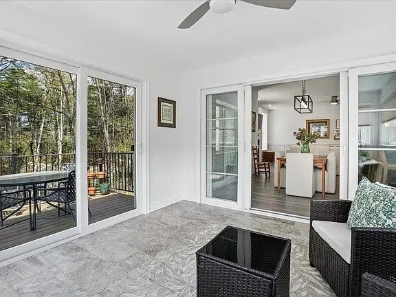 Sunroom with sliding glass doors, wicker seating, and a stone-look tile floor