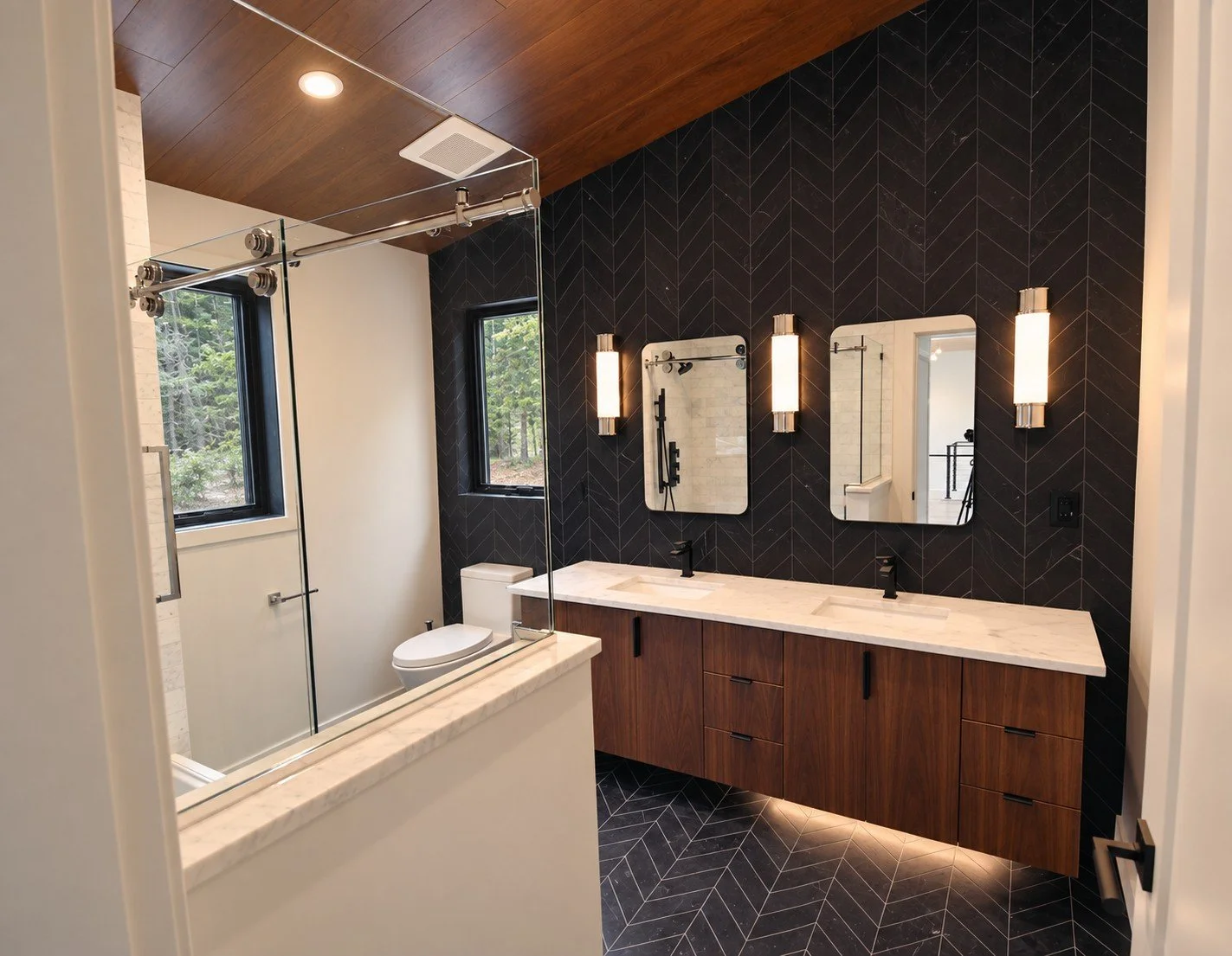 Bathroom with a floating walnut vanity, a dark herringbone tile wall, and a wood ceiling