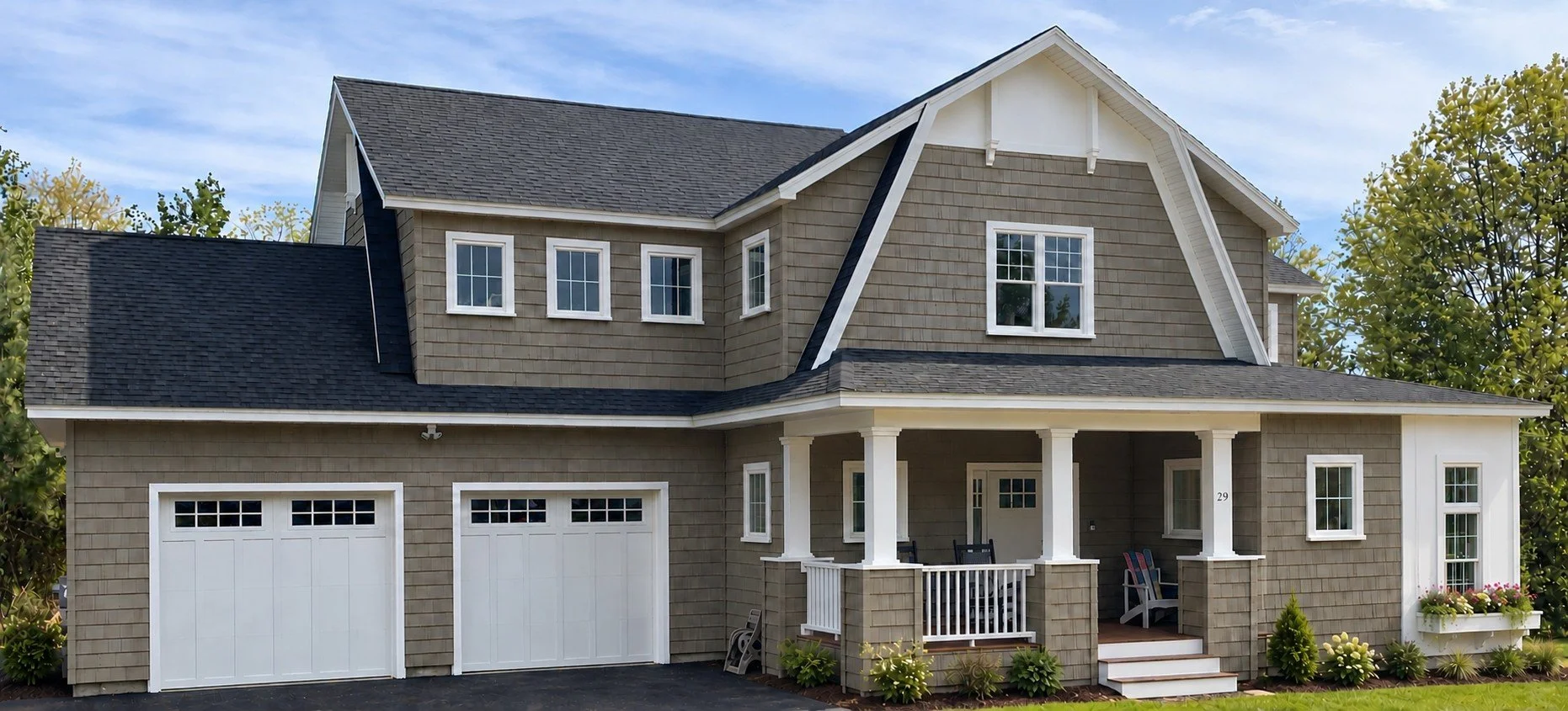 Front of the shingle-style home with two white garage doors, a covered porch, and a gambrel roof