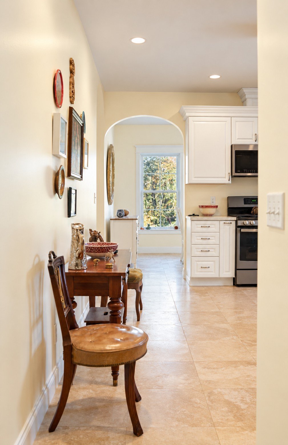 Hallway with an arched opening to the breakfast nook and kitchen