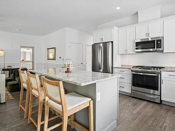 Eat-in kitchen island with three wood stools and a stainless steel range