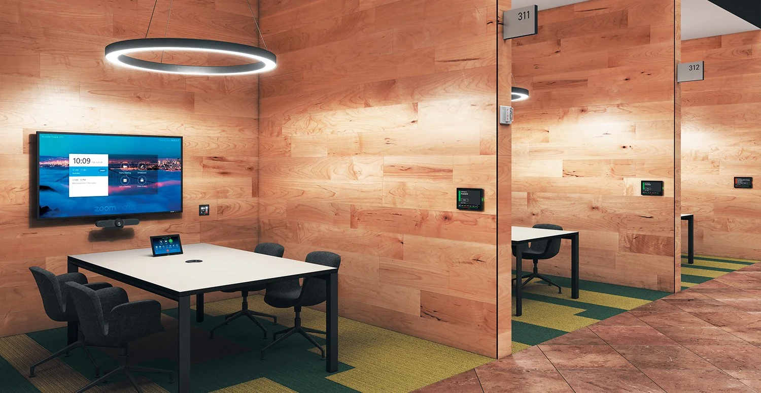 A modern office meeting room with wooden walls, a large monitor, a conference table with chairs, and enclosed individual workspaces with numbered signs.