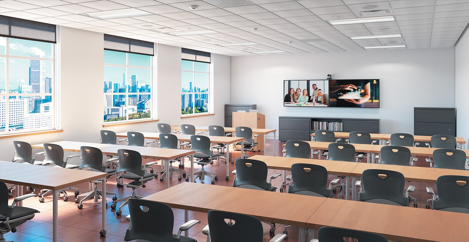 Empty modern classroom or conference room with multiple rows of black chairs and light brown tables, large windows with city skyline view, wall-mounted TV screens, and a cabinet