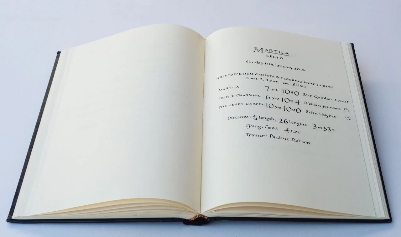 Open guest book with handwritten notes about a horse jumping event, including details like date, location, horses' names, trainers, and event results.