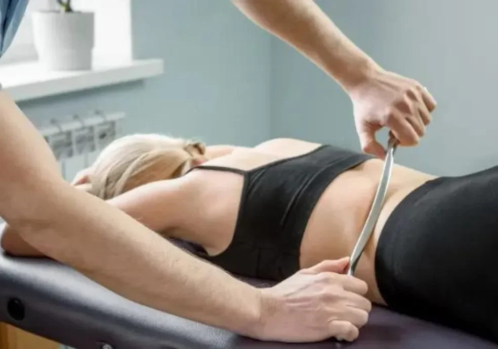 A healthcare professional measures a woman's waist with a measuring tape during a medical examination in a clinic.