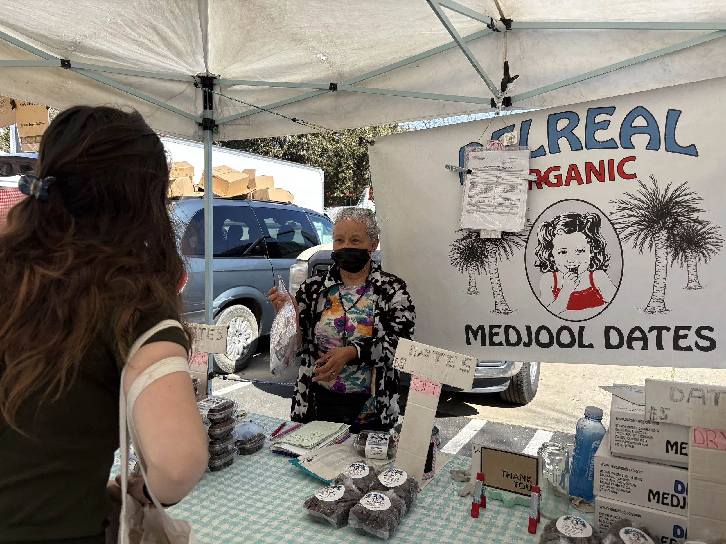 A woman giving eyewear to older woman.