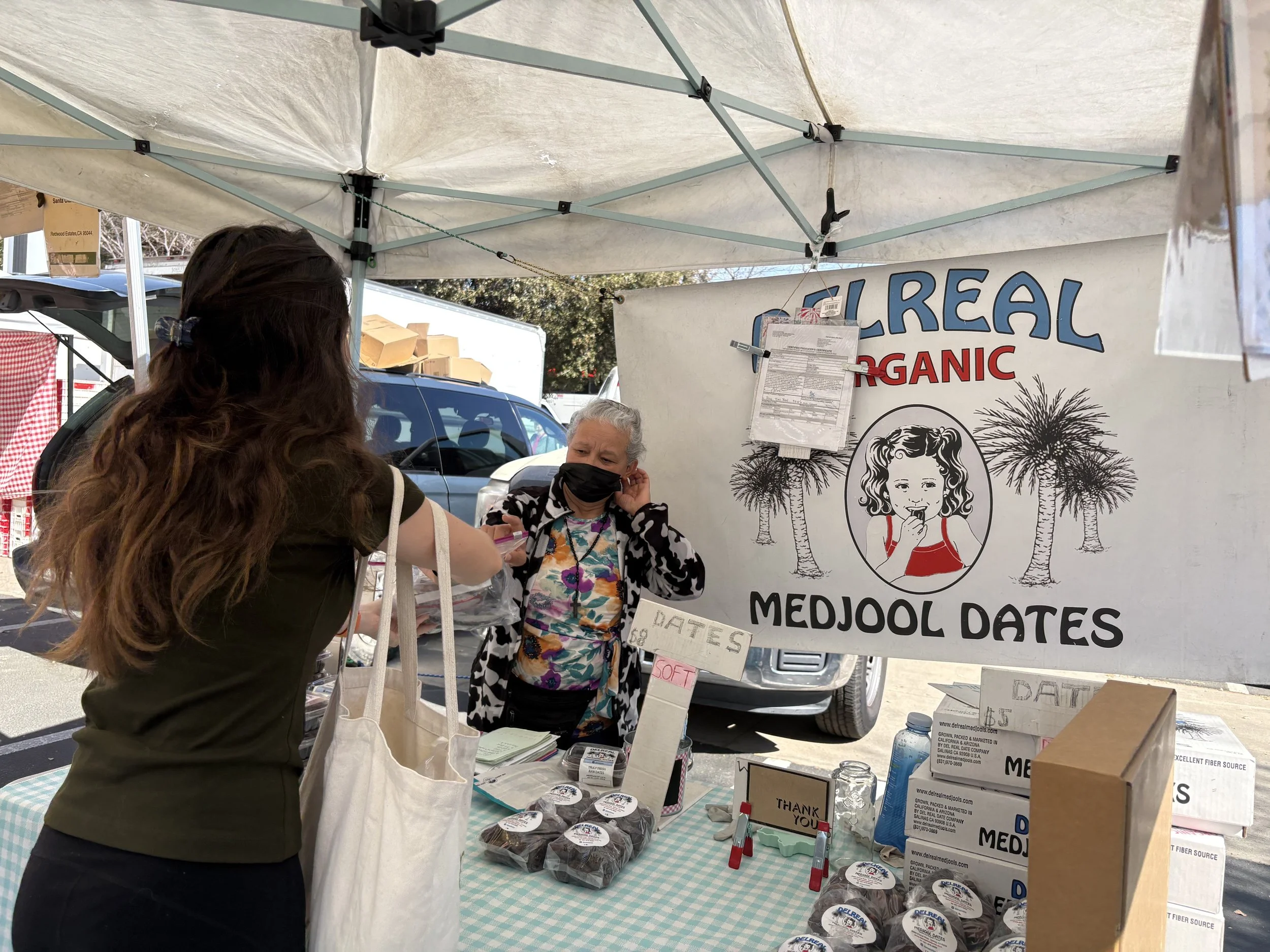 A woman giving eyewear to older woman.