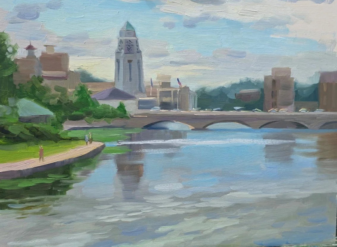 A painted landscape of a city with a river in the foreground, a bridge, a tower, and several buildings under a cloudy sky.