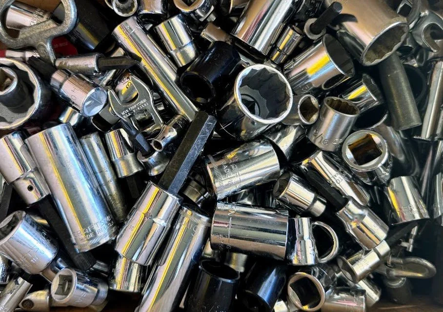 A large pile of used chrome socket wrenches of various sizes.