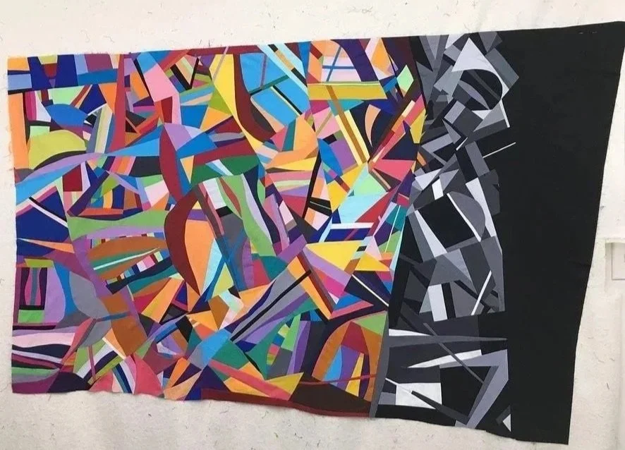 Love and Loss, an improvisational quilt by Kenny Smith, with saturated geometric color dissolving into black, white, and gray.