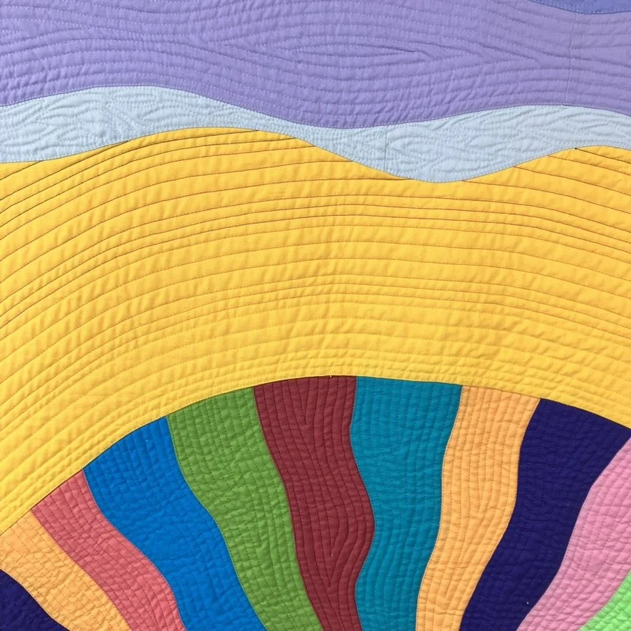 Close-up of the quilting where the warmth of the sunset transitions into the quieter movement of the clouds.