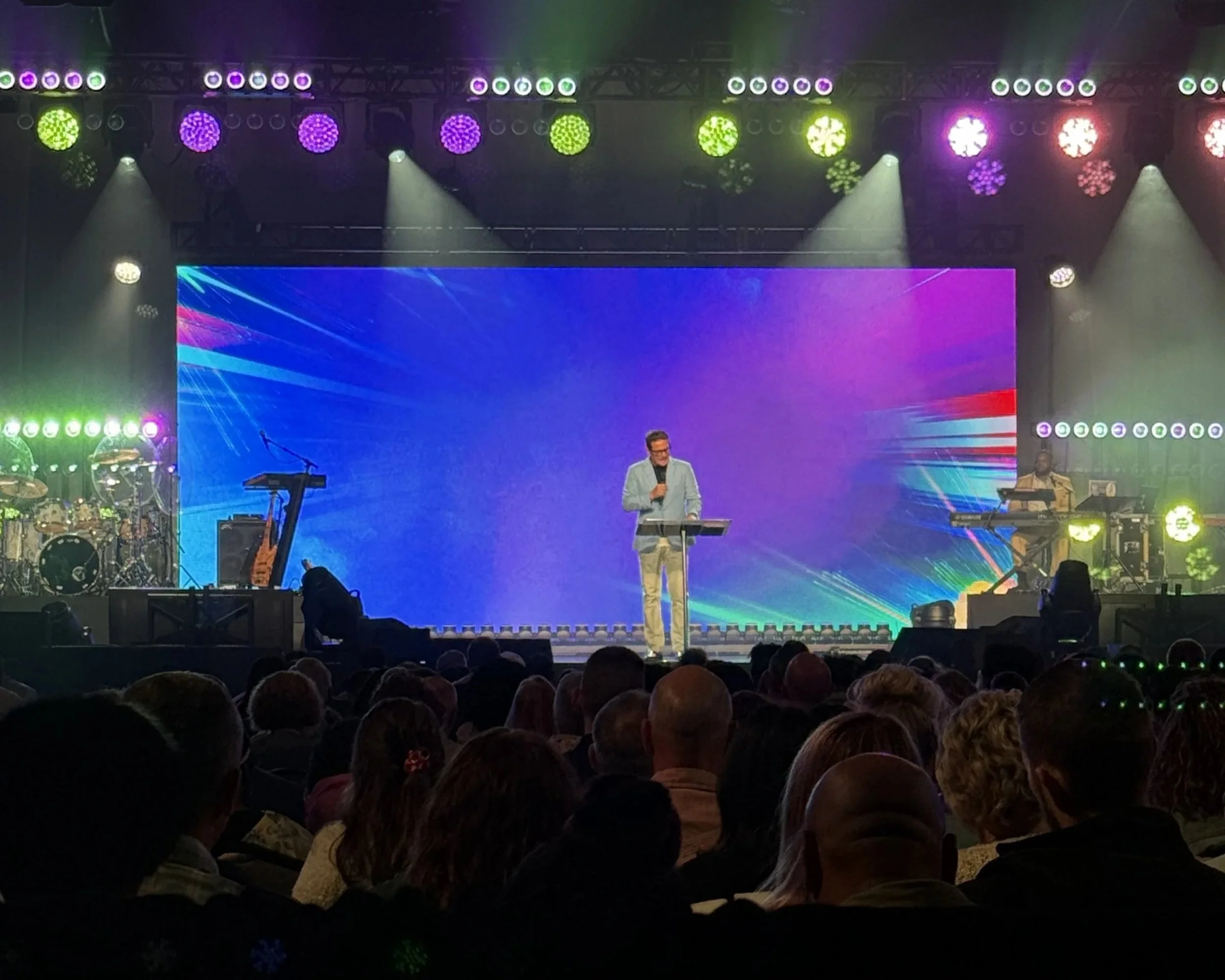 Speaker on stage in front of led video wall.