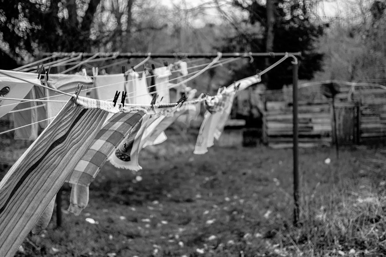 Clothes hanging on a clothesline outdoors in a backyard.