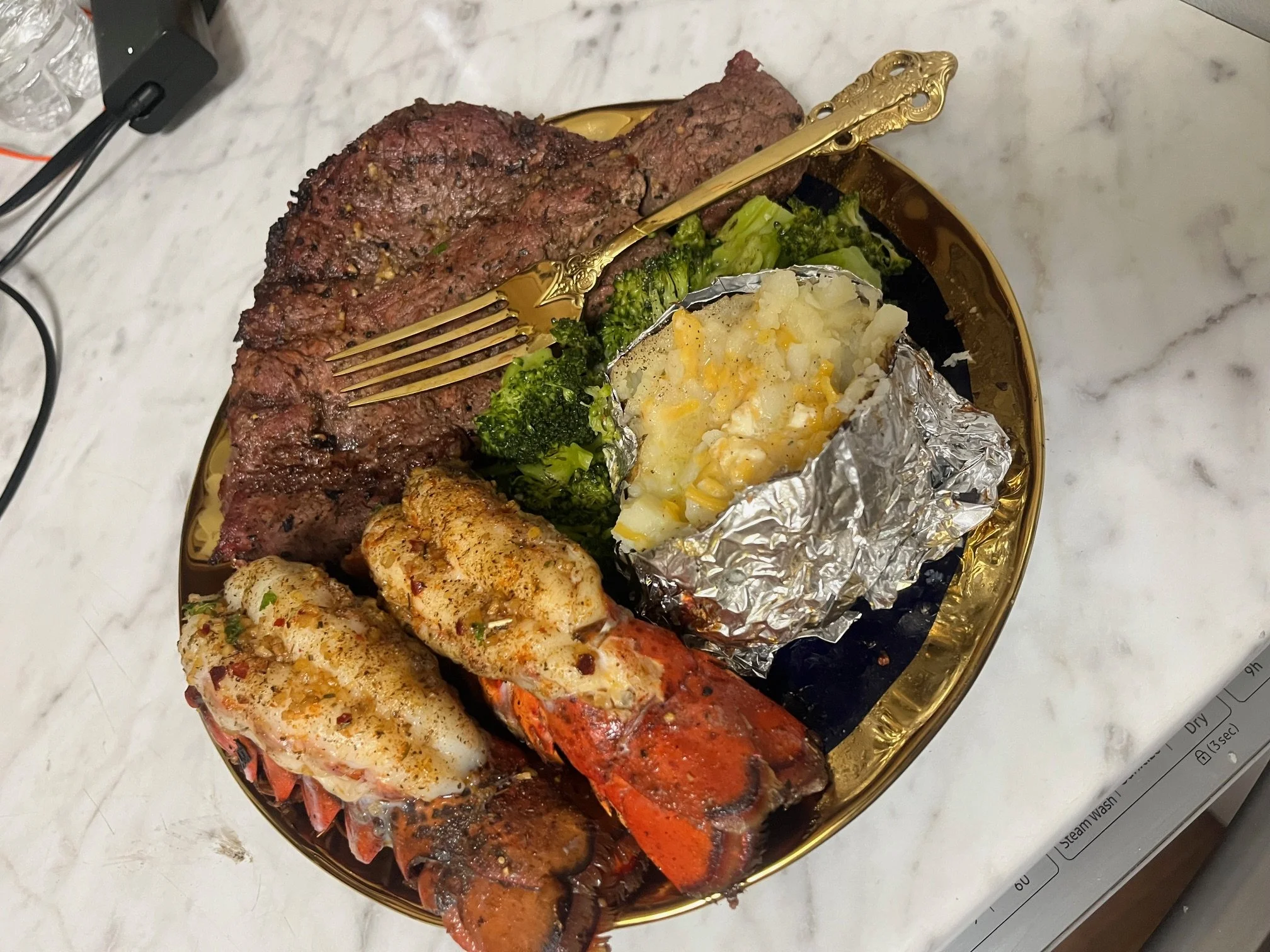 Gourmet steak and lobster tails plated with herbs, private chef dining experience in Kentucky
