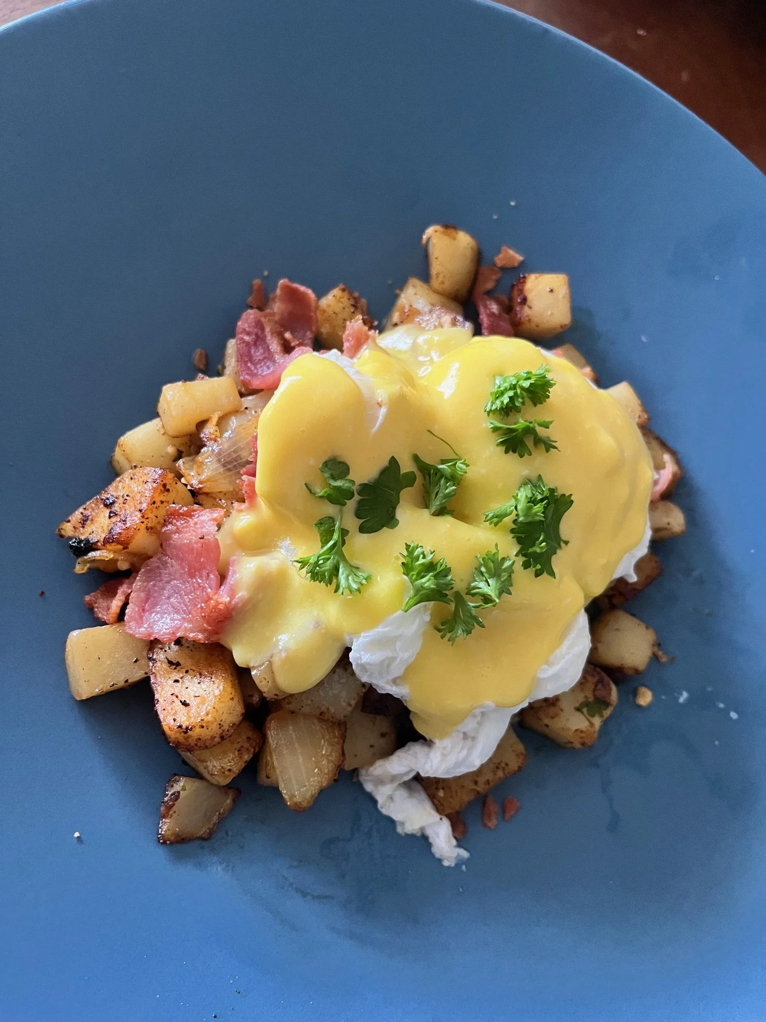 Classic eggs benedict with silky hollandaise, served with roasted potatoes, part of a luxury in-home dining experience