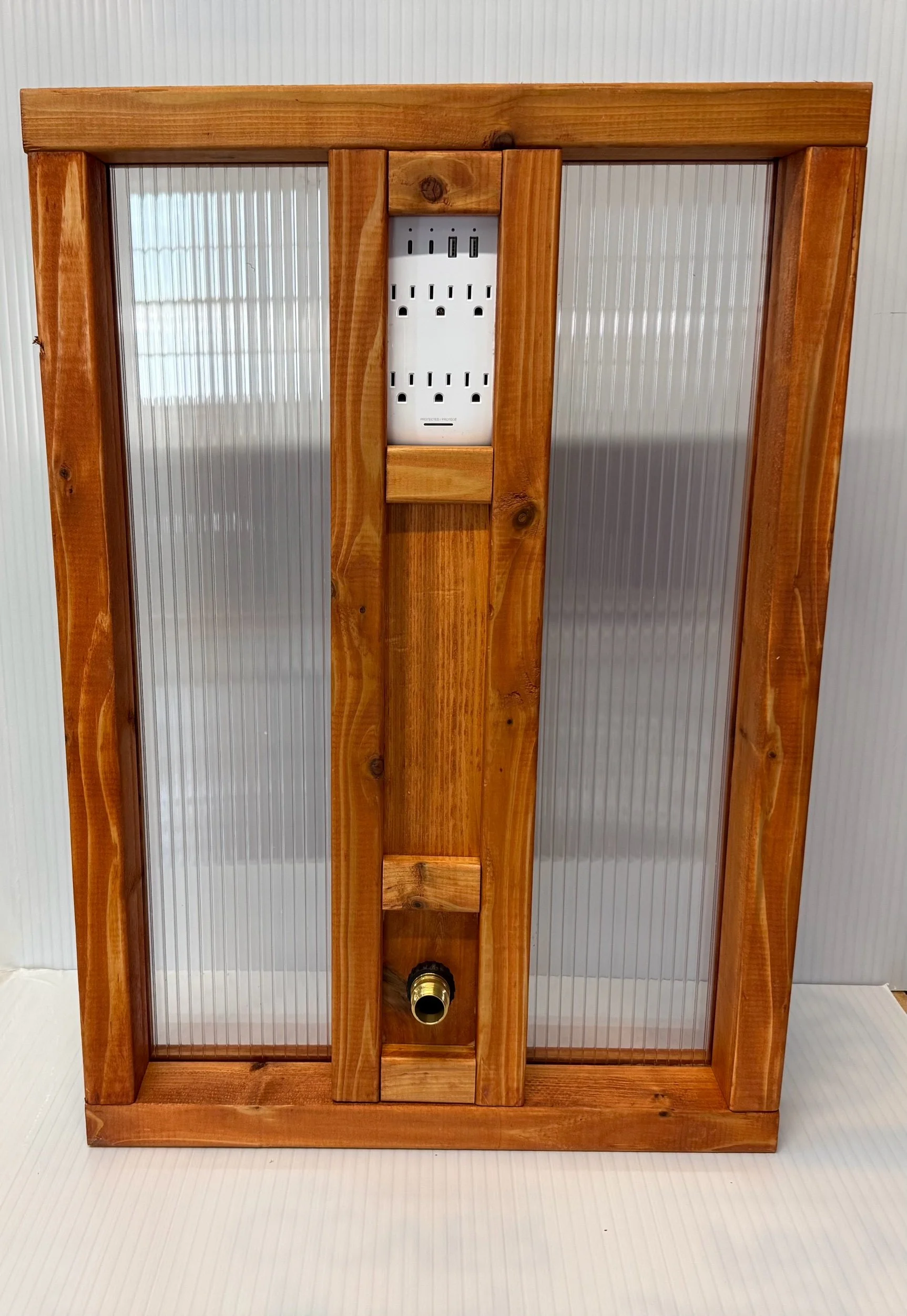 Wooden utility panel with outlets and water spigot, angled view