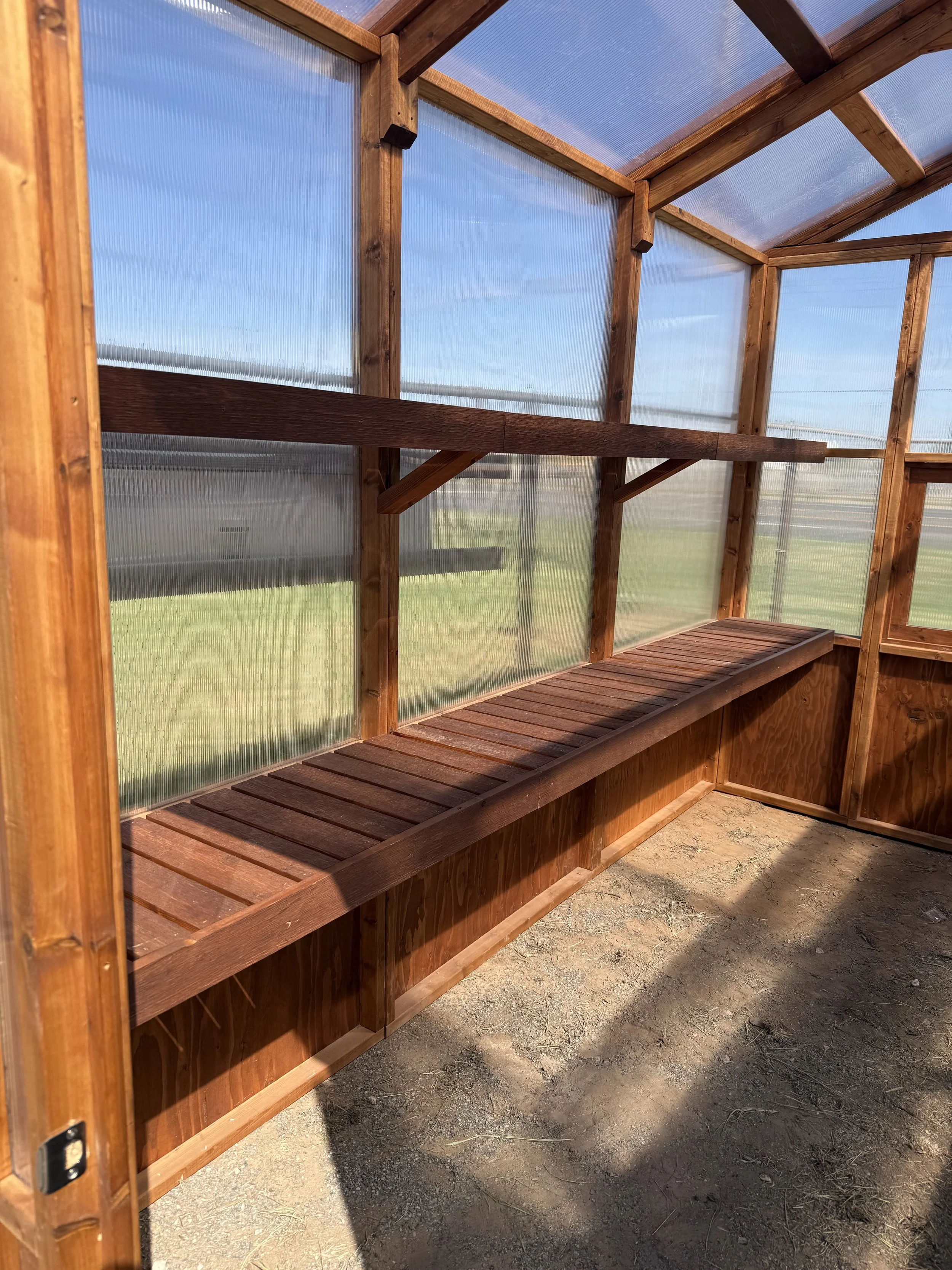 Interior of cedar greenhouse with wooden workbench
