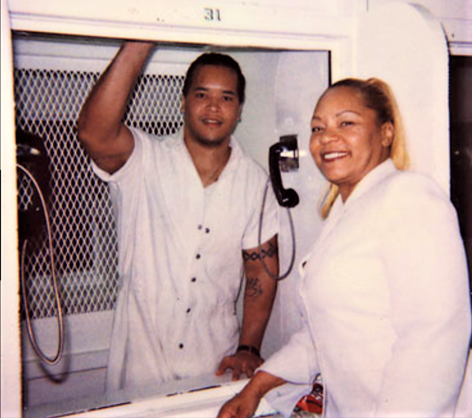 Nanon Williams with his mother during a prison visit - Nanon is behind a glass wall of separation.