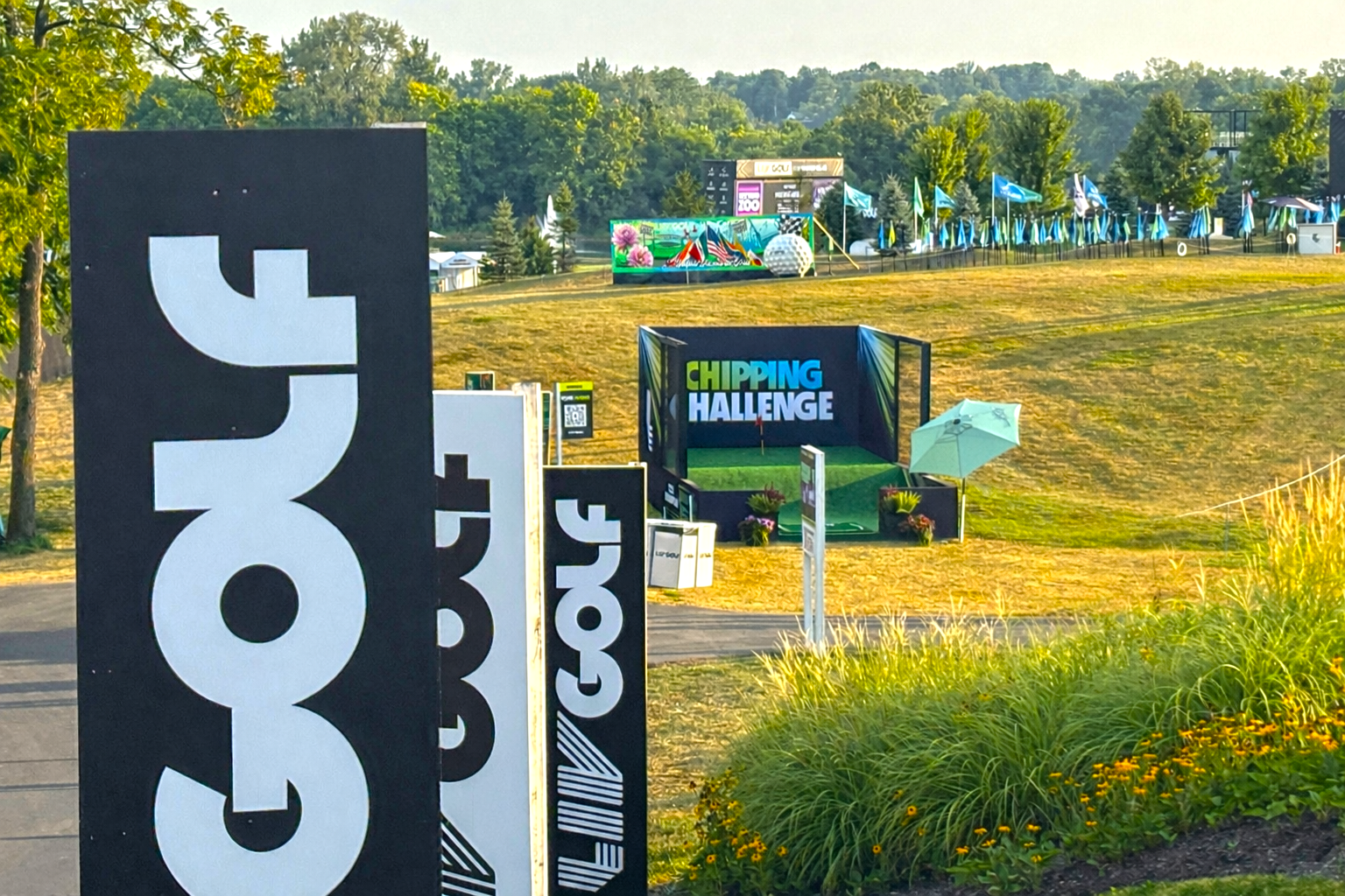 Golf course with signs advertising a 'Golf' event and a 'Chipping Challenge' area. LIV GOLF ARCY LIVE EVENT MURAL INDIANAPOLIS INDIANA