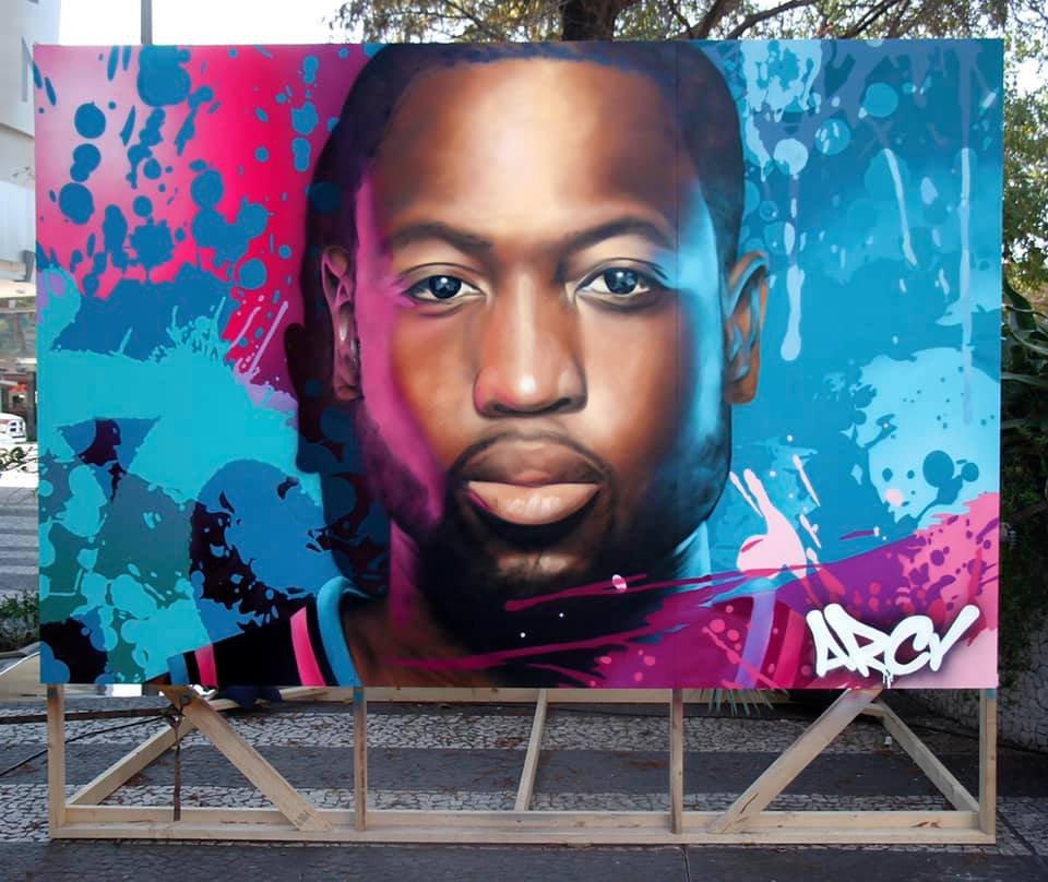 Colorful mural of a young man's face with digital-style pink, blue, and purple splashes and graffiti tags. DWAYNE WADE ARCY LIVE EVENT MURALS THE DAN PATRICK SHOW MIAMI FLORIDA SUPER BOWL WEEK