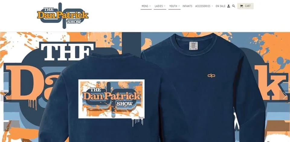 A navy blue sweatshirt with the logo of 'The Dan Patrick Show' and an orange and blue graphic background. ARCY
