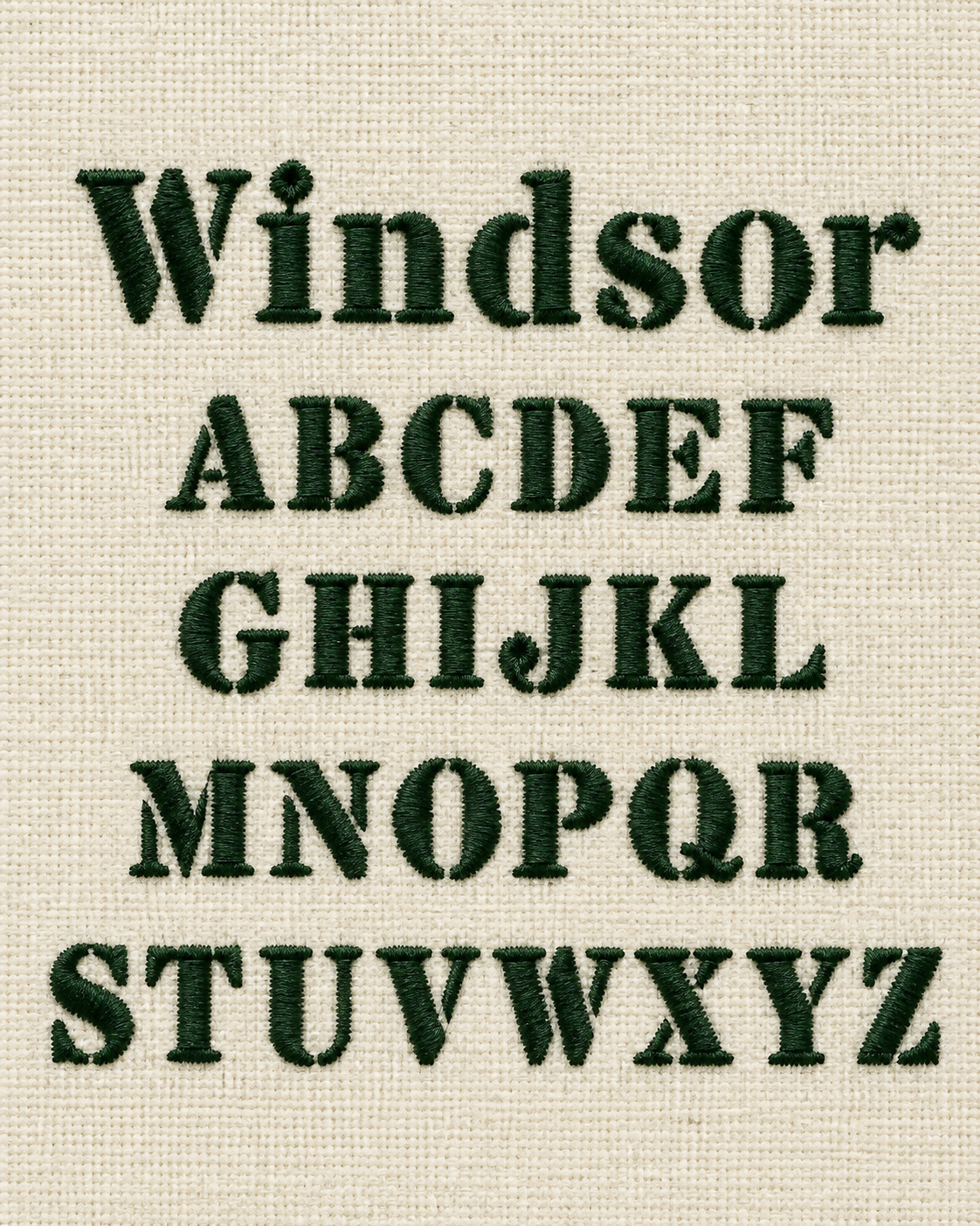 Embroidery of the English alphabet from A to Z in dark green thread on cream fabric.