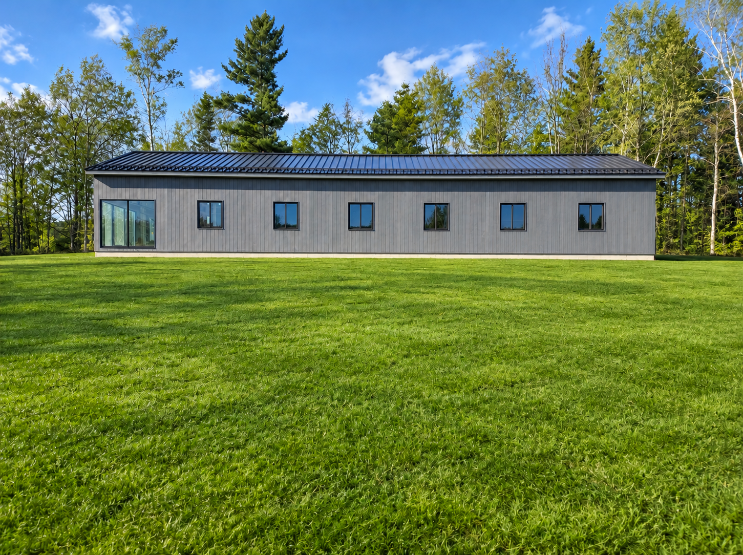 Modern Gray Barn House on a Green Lawn.png